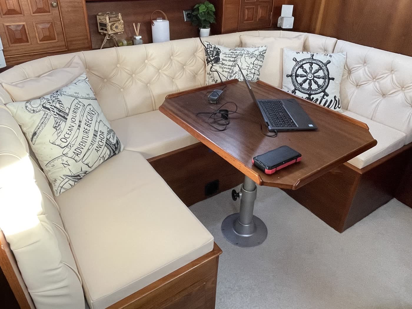 Neu bezogene Polsterbank im Salon einer Yacht, cremefarbenes Leder mit Knopfheftung